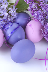 Colorful easter eggs in a basket with lilac