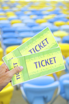 Soccer Fan Holding Two Brazil Tickets at Stadium