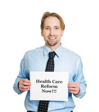 Happy business man holding healthcare reform now! sign