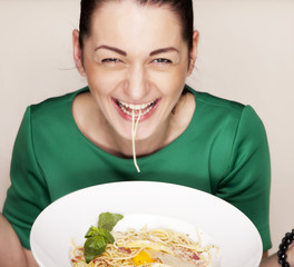 Happy smiling young woman eating spaghetti 