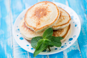 Glass plate with fritters and mint leaves, horizontal shot
