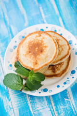 Freshly made pancakes in a glass plate, high angle view