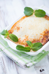 Close-up of lasagna decorated with mint leaves, vertical shot