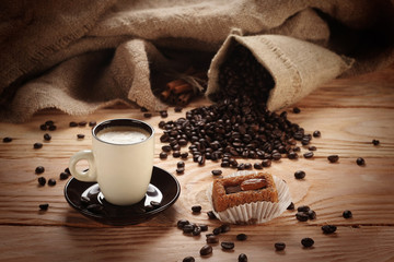 A hot cup of espresso with coffee beans and Cake