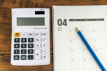 April organizer with calculator & pencil: concept for monthly bu