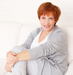 Naklejka premium Happy mature woman on sofa