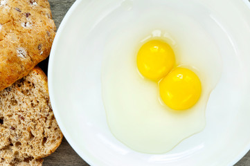 Quail eggs yolk in white porcelain bowl. Indoors closeup.