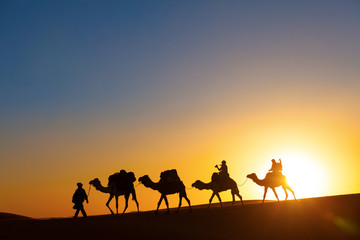 Camel caravan going through the desert - obrazy, fototapety, plakaty