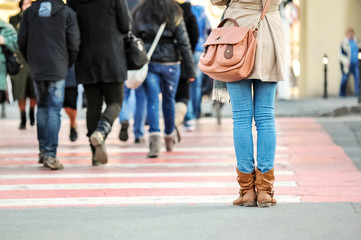 Woman at pedestrian crossing with crowd on background - obrazy, fototapety, plakaty