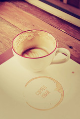 Coffee cup on book on wooden table