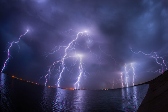 Thunderstorm and lightnings in night over a lake with reflaction