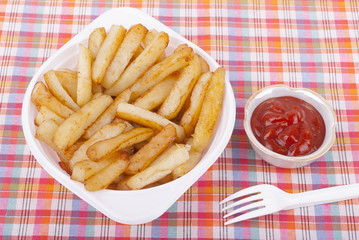 Fried potatoes in a plate on a tablecloth.