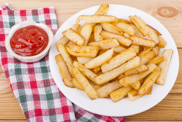 Fried potatoes in a plate on a tablecloth.