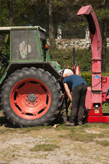 Obraz premium En panne ? Un agriculteur examine son tracteur