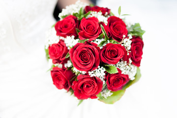Hochzeit - Braut hält Brautstrauß mit roten Rosen