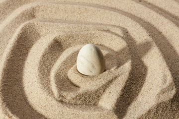 Fototapeta na wymiar White stone sticking out of the sand