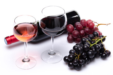 Bottle and glasses of wine with red and black grapes
