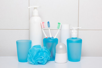 set of blue hygiene supplies over tiled wall