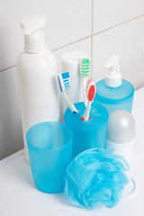 Fototapeta na wymiar set of blue hygiene supplies over tiled wall in bathroom