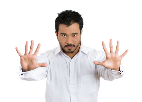 Serious, upset, man giving Stop hand gesture, white background 