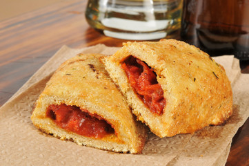 Closeup of pizza pockets and beer