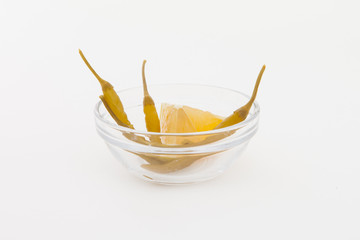 Glass filled with pickled Chilis peppers and cube of lemon