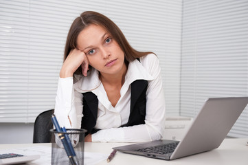 tired young business woman with laptop computer at the office