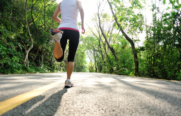 fitness woman running at forest road 