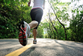fitness woman running at forest road 