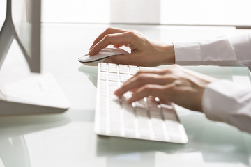 Close-up of hands woman using a mouse and keyboard computer