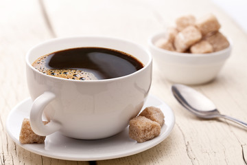 Cup of coffee with sugar cubes.