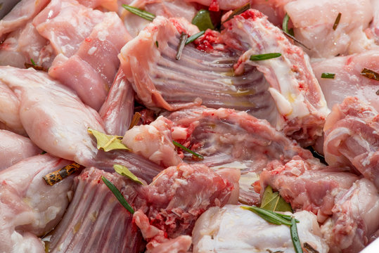Pezzi di coniglio crudo nella teglia per essere cucinato