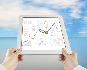 Hand holding tablet with business concept doodles and clock hand