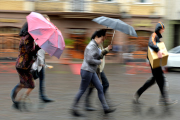 Group of people walking down the street in rainy day