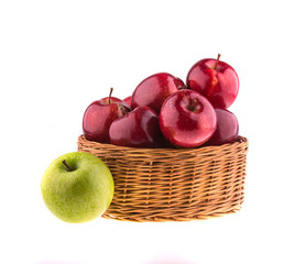 Red and green apples in a wicker baskets, isolated