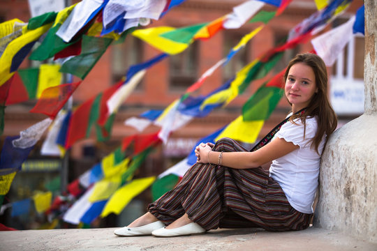 Young girl sitting on Buddhist stupa.