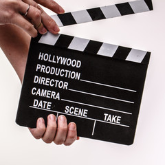 Movie flapper in woman´s hands on white background