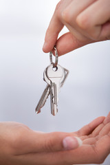 Agent's Hand Giving New Home Keys To Woman