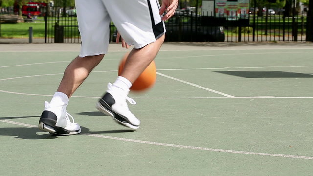 Low angle of basketball player dribbling the ball