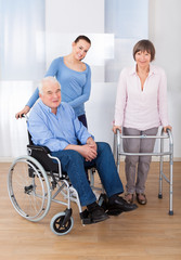 Fototapeta na wymiar Disabled Senior Couple With Caregiver