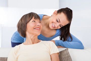 Portrait Of Happy Caregiver With Senior Woman