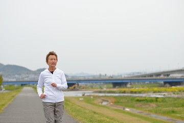 ランニングコースを健康のために走る高齢の日本人女性