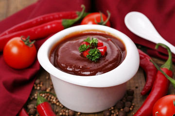 Tomato sauce in bowl on wooden table close-up