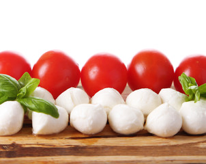 Tasty mozzarella cheese balls with basil and red tomatoes,