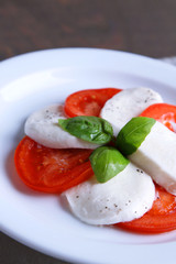 Caprese salad with mozarella cheese, tomatoes and basil