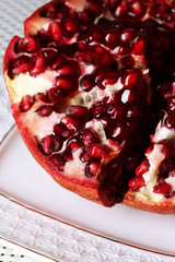 Ripe pomegranate on plate,  on light background