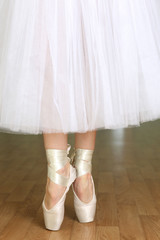 Ballerina legs in pointes in dancing hall © Africa Studio