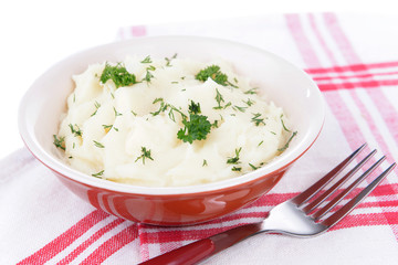 Delicious mashed potatoes with greens in bowl on table close-up