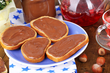 Bread with sweet chocolate hazelnut spread on plate on table
