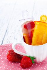 Fruit ice cream in cup on wooden table close-up